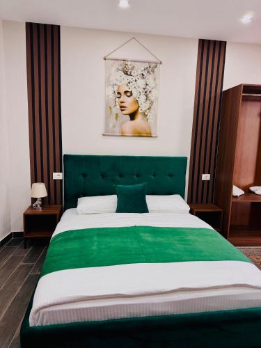 a bedroom with a green bed with a green headboard at Andor Luxury Hotel & Duplex in Durrës