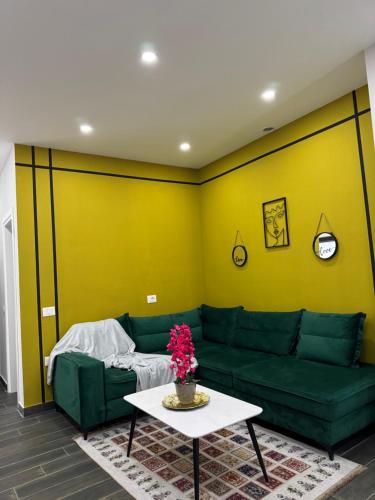 a living room with a green couch and a table at Andor Luxury Hotel & Duplex in Durrës
