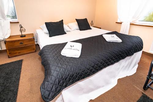 a bedroom with two beds with black comforter at Folwark Nadmorska Ostoja in Mechelinki