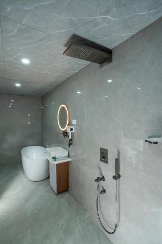 a bathroom with a tub and a sink and a shower at Hotel Sri Ashvik Rameswaram in Rāmeswaram