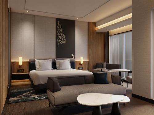a hotel room with a bed and a couch at Grand Mercure Batam Centre in Batam Center