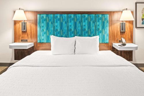a bedroom with a large white bed and two lights at Hampton Inn Columbus-North in Columbus