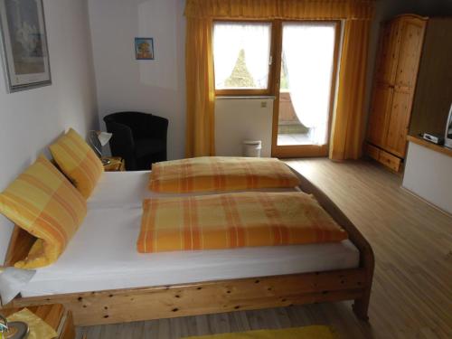 ein Schlafzimmer mit einem Bett mit zwei Kissen und einem Fenster in der Unterkunft Gasthof Pension Gregori in Bad Koetzting