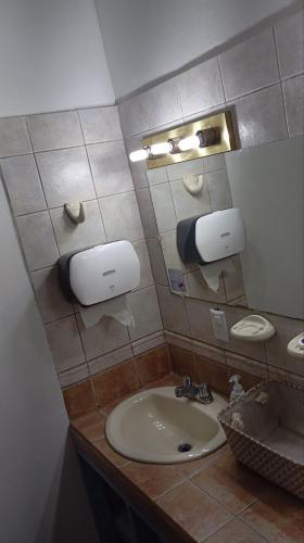 a bathroom with a sink and a mirror at Hostel Casa Ridgway in San José