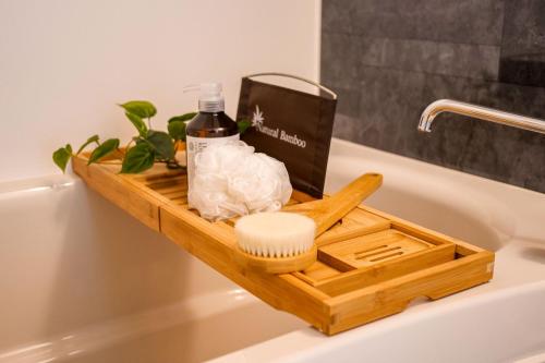 a wooden tray on the side of a bath tub at Premium Apartment Hotel Tokyo East in Tokyo