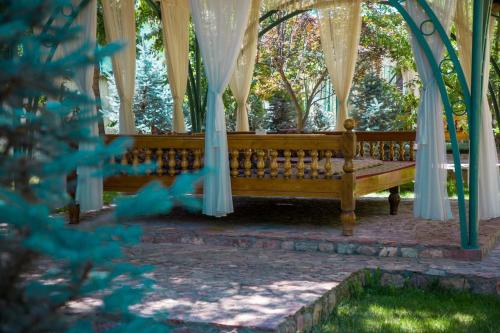 a wooden bench sitting under a gazebo at HUMSON BULOQ SANATORIUM in Khumson