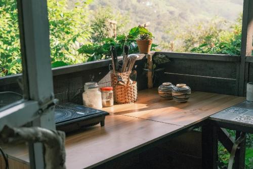 a table with utensils on a balcony with a window at Cú Trên Cây Homestay in Xuan An