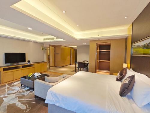 a hotel room with a large bed and a tv at Somerset Grandview Shenzhen in Shenzhen
