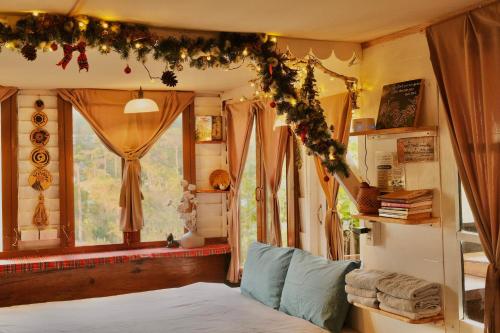 a bedroom with a bed and a window with christmas decorations at Cú Trên Cây Homestay in Xuan An
