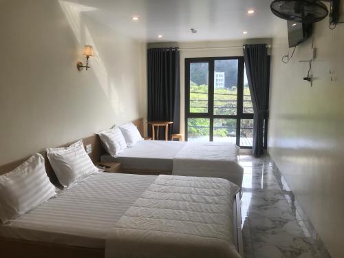 カットバ島にあるAnh Như Lake View Hostel Cat Baのベッドが2つと窓があるホテルの部屋