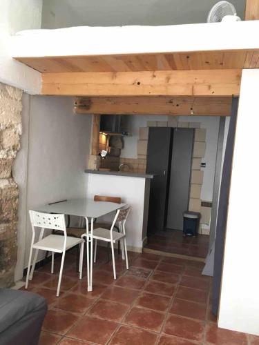 une cuisine avec une table et des chaises dans une pièce dans l'établissement studio Avignon Intra-Muros, à Avignon