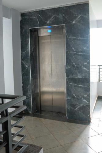 a elevator in a building with a marble wall at Mariehomes in Thika