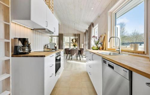 a kitchen with white cabinets and a large window at 4 Bedroom Nice Home In Højby in Højby