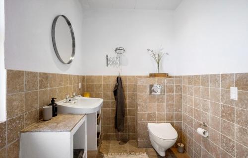 a bathroom with a sink and a toilet and a mirror at 4 Bedroom Awesome Home In Frørup in Frørup