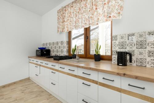 a kitchen with white cabinets and a window at Krab in Rewal