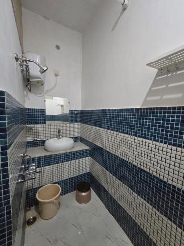 a bathroom with a sink and blue and white tiles at Shri Shyam Kunj in Ayodhya