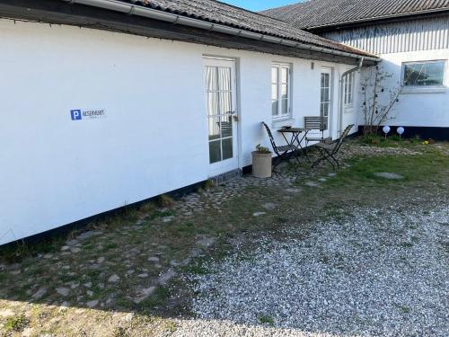 a white house with a bench in front of it at Bakkely in Hjortshøj