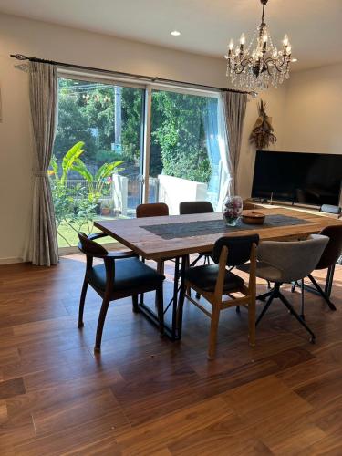 a dining room with a wooden table and chairs at Cottage in Tokashiki MIUFUYA in Tokashiki