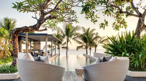 a resort with a swimming pool and palm trees at Soori Bali in Tabanan