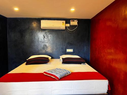 a bedroom with a large bed with a red wall at The Nature swimming resort in Puducherry