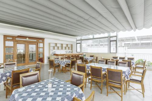 a dining room with tables and chairs and windows at Hanoi Sail Hotel in Hanoi