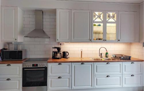 a kitchen with white cabinets and a sink at Lovely Home In Heberg With Wifi in Heberg