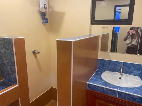 a bathroom with a sink and a mirror at Siargao Sunset Bay Beach Villas in General Luna