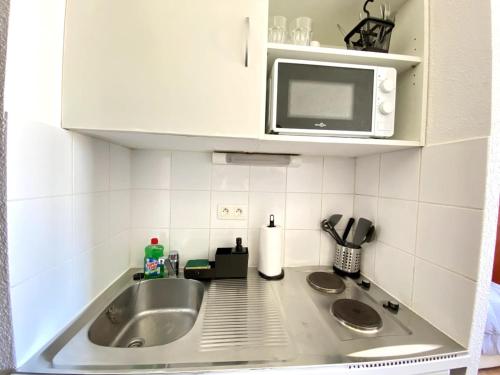 un comptoir de cuisine avec un évier et un micro-ondes dans l'établissement Studio Cosy à deux pas du centre Avignon Clim, à Avignon