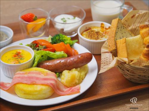 a plate of food with a sausage and vegetables on a table at Daiwa Roynet Hotel Fukuyama Ekimae in Fukuyama