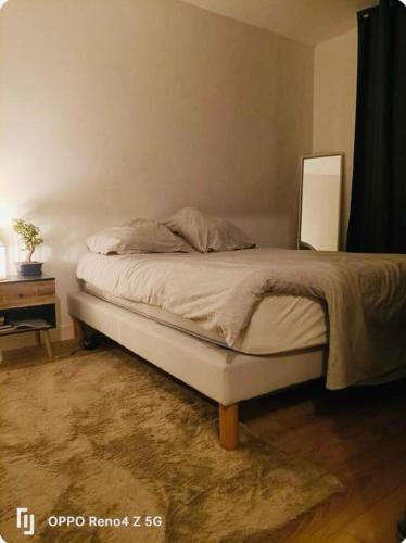 Ce lit se trouve dans une chambre dotée d'une table et d'un lit sidx sidx. dans l'établissement Maison jardin spa a Bordeaux, à Mérignac