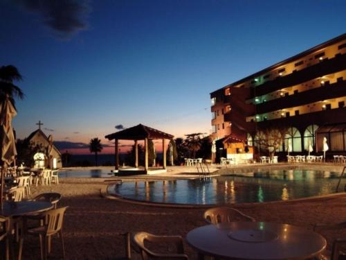 a building with a pool and tables and chairs at Resort Hotel Umibe no Kajuen in Konan