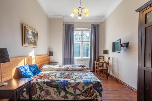 a bedroom with two beds and a desk and a window at Pałac Myśliwski Orle Solutions in Mirosławiec