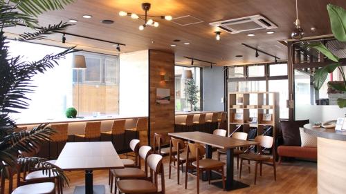 a restaurant with tables and chairs and a bar at Hotel Resh Tottori Ekimae in Tottori
