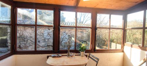 Cette chambre dispose d'une table en bois devant les fenêtres. dans l'établissement La Campagne Provençale, à Le Val