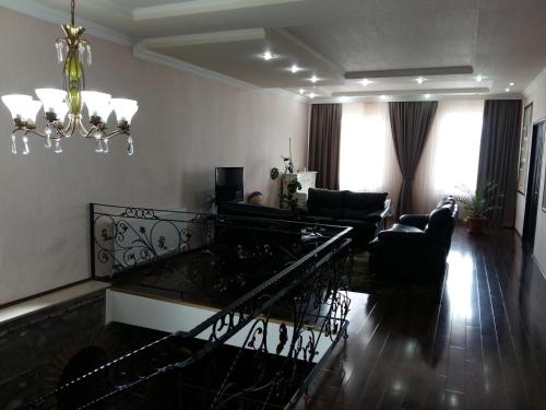a living room with a couch and a chandelier at Marinella in Tʼelavi