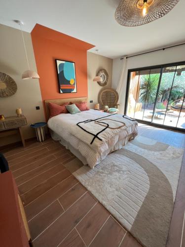 une chambre avec un lit avec un mur orange dans l'établissement Villa avec piscine 3 chambres 6 couchages, à Cazaux