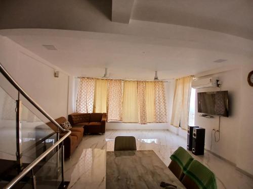 a living room with a couch and a table at Nikhat villa 61 in Harnai
