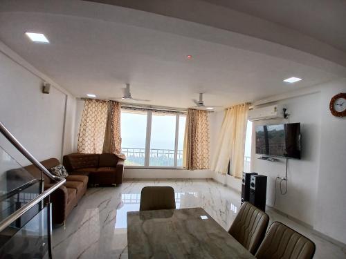 a living room with a table and a couch at Nikhat villa 61 in Harnai