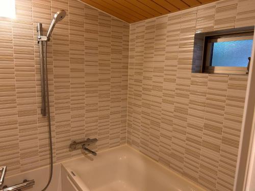 a bathroom with a bath tub and a shower at Shin Kadoya in Atami