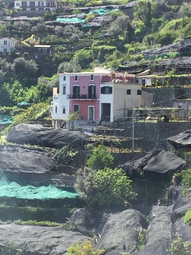 a pink house on a hill next to a river at Casa Rossa in Ravello