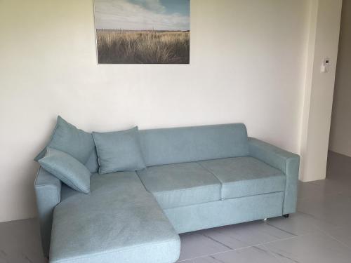 a blue couch in a room with a picture on the wall at Sondol Guesthouse in Loon