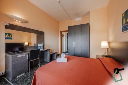 a room with a bed and a desk and a television at HOTIDAY Room Collection - Varazze in Varazze
