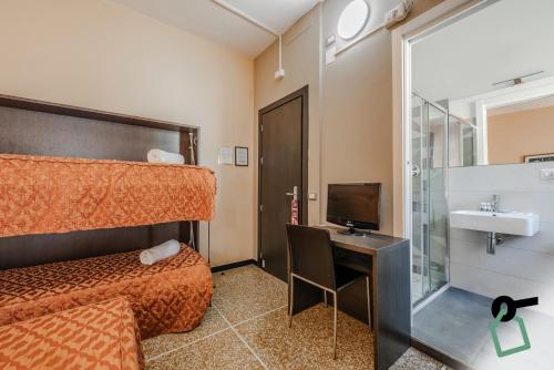 a bedroom with a bed and a desk with a television at HOTIDAY Room Collection - Varazze in Varazze