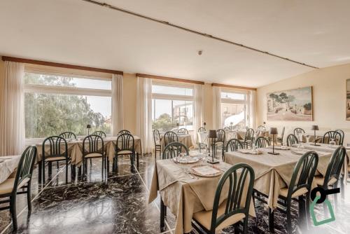 a dining room with tables and chairs and windows at HOTIDAY Room Collection - Varazze in Varazze