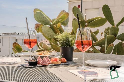 a table with two glasses of wine and a cactus at HOTIDAY Room Collection - Varazze in Varazze