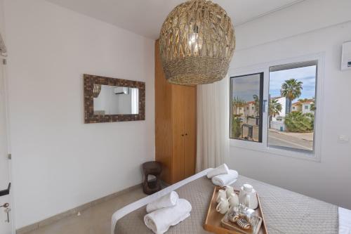 Habitación con mesa, toallas y lámpara de araña. en EvelMar Villa, en Protaras