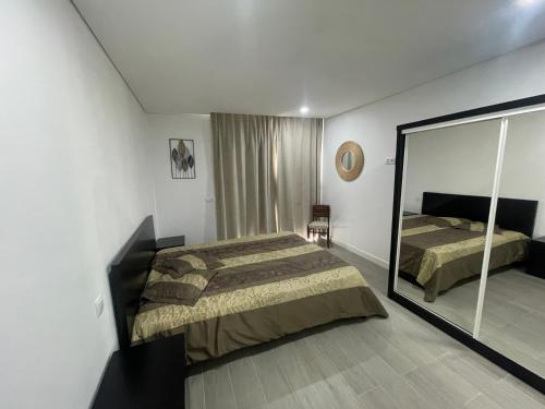 una camera da letto con un letto e un grande specchio di casa do gaio a Geres
