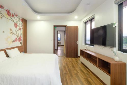 a bedroom with a large bed and a flat screen tv at Chuỗi Villa FLC 5 NGỦ 9-48 - bể bơi riêng - trung tâm Hạ Long in Ha Long