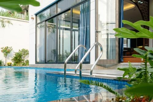 a swimming pool in front of a house at Chuỗi Villa FLC 5 NGỦ 9-48 - bể bơi riêng - trung tâm Hạ Long in Ha Long