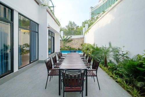 a long table and chairs on a patio at Chuỗi Villa FLC 5 NGỦ 9-48 - bể bơi riêng - trung tâm Hạ Long in Ha Long